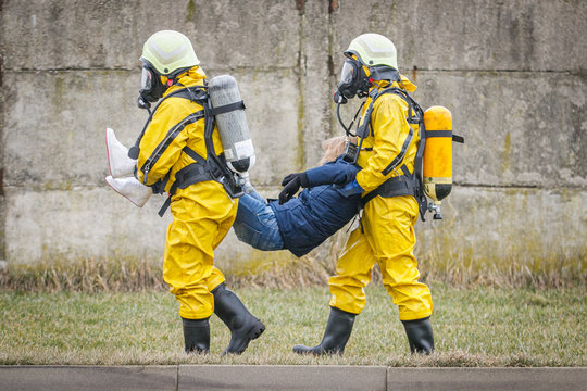 Rescuers  with protective carry injured person. Biohazard, virus, chemical disaster
