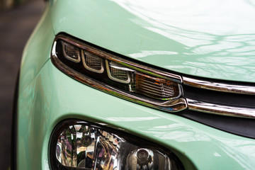 Close up photo of modern car, detail of headlight. Headlight car Projector LED of a modern luxury...