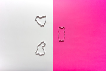 Shapes and stencils of Easter bunny rabbit and chick on pink and white background