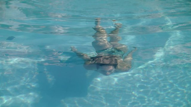 Young Girl Swims Underwater In The Pool.