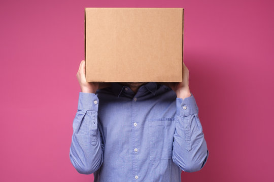 Anonymous business man with a cardboard box on his head concealing his identity
