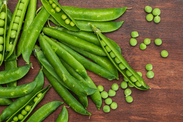 Green, tender, fresh and raw peas. Close-up and top view. Rustic appearance. Rustic appearance. Black background.