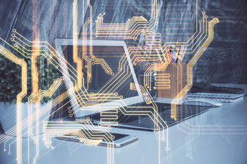 Computer on desktop in office with technology theme hologram. Multi exposure. Tech concept.