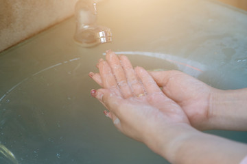 Fototapeta premium Women wash their hands properly before eating with water tap