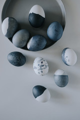 Naturally dyed blue eggs prepared for Easter on white background. Easter background with Easter eggs in a ceramic gray bowl. 