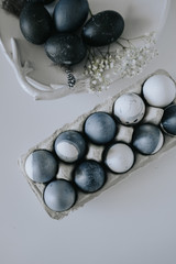 natural-dye Easter eggs lying in tray . Background with easter eggs. Naturally dyed eggs prepared for Easter on gray texture tablecloth background. Happy Easter card. 