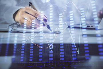 Double exposure of woman's hands making notes with forex graph hologram. Concept technical analysis.