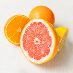 grapefruit and orange halves on a white table without a background square orientation