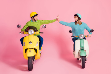 Full length photo of funny cheerful lady guy driving two vintage moped spend vacation together clapping arms one team wear casual sweater headgear isolated pink color background