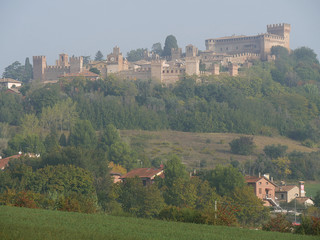 Fototapeta na wymiar Panorama of Gradara village with walls, towers and the fortress on the hill over the the green countryside