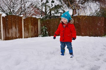 Fototapeta na wymiar little boy playing in the snow