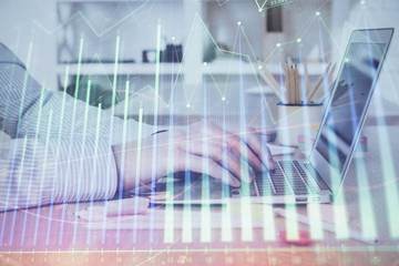 Double exposure of stock market graph with man working on laptop on background. Concept of...