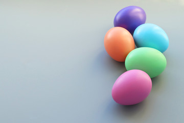 A group of Easter colored eggs painted with bright colors on a gray background. Selective focus.Copy space