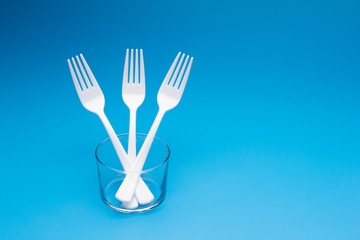 Teaspoon and plastic fork and glass tumbler