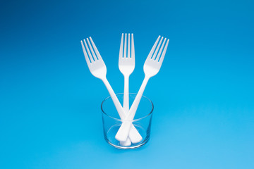Teaspoon and plastic fork and glass tumbler