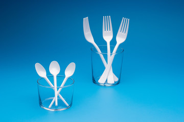 Teaspoon and plastic fork and glass tumbler