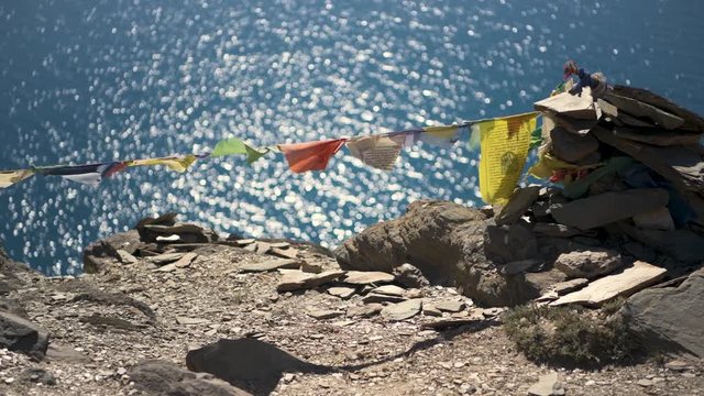 Colorful various buddhist prayer flags against rocks and lake in Ladakh, Kashmir, India