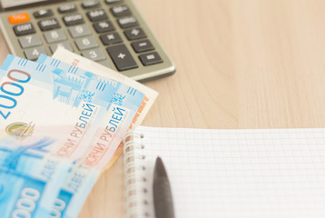 Money.Russian rubles, a calculator and a notebook for writing on the table.The concept of...