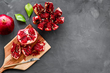 Peel pomegranate. Open fruit on cutting board on grey background top-down copy space