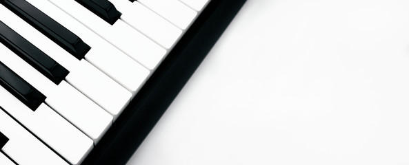 Close-up side view of synthesizer on white background. Digital keyboard. Musical instrument. Black and white piano keys. Entertainment concept. Web, social media banner template. Stock photo.