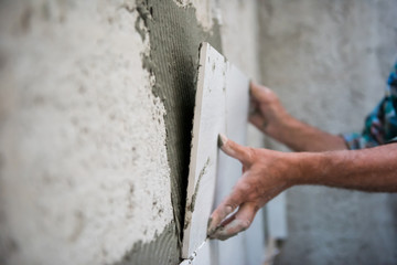 worker installing big ceramic tiles