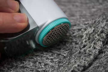 Closeup of balls shaving on grey woolen pullover