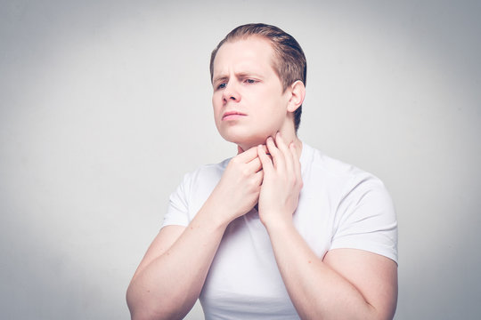 A Man Massages His Neck While Feeling For A Furuncle Near His Neck. The Concept Of A Weak Immune System.