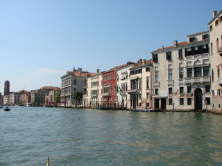 Fototapeta premium The beauty of the unique Venetian architecture surrounded by water streets and avenues against the backdrop of a clear blue summer sky.