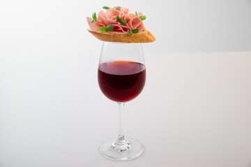 Glass of red wine with salami sandwich