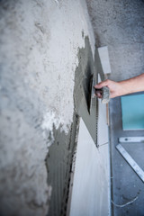worker installing big ceramic tiles