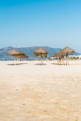 Set of umbrellas on the beach with mountain in the background