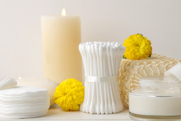 Various personal care products. Soap, Cotton pads, washcloth, sticks and yellow flowers on a white background. spa