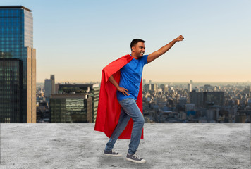 super power and people concept - indian man in red superhero cape making winning gesture over tokyo...