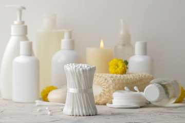 Various personal care products. Cotton pads close-up and sticks and yellow flowers on a white background