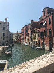 The unique landscape of the narrow waterways of sunny Venice, connected by small numerous bridges.