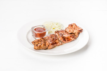 In a white plate kebab with onions and sauce