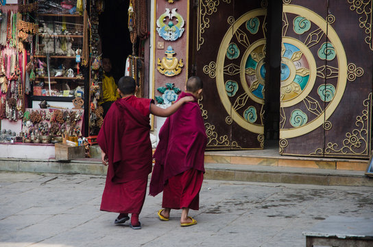 Dos j&oacute;venes aprendices de monjes budistas caminando hacia la entrada del templo