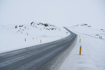 Rural curve highway road among the snow mountain in Iceland