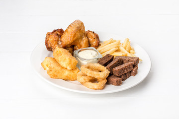 Onion, rings, croutons, french fries, chicken on a white plate