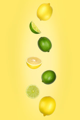 Falling lemons and limes isolated on yellow background with clipping path. Flying fruits.