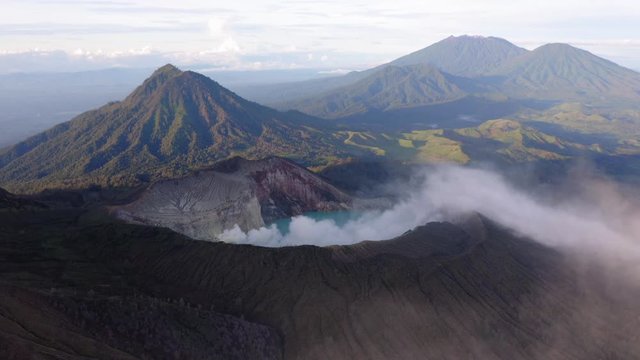 Sunrise in Ijen volcano, Java, Indonesia. Landscape with the green lake and the smoke