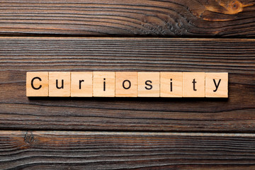 curiosity word written on wood block. curiosity text on table, concept