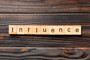influence word written on wood block. influence text on table, concept