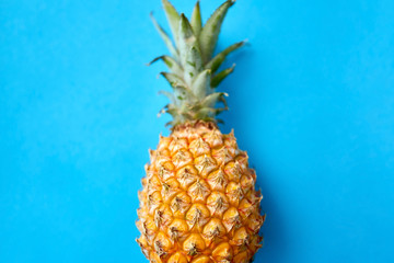 food, fruits and healthy eating concept - close up of pineapple on blue background