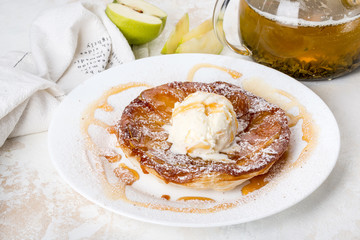 In a white plate strudel with ice cream and sweet syrup
