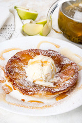 In a white plate strudel with ice cream and sweet syrup