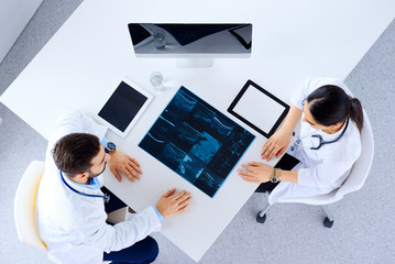Doctor or surgeon with spine x-ray and clipboards at hospital, medicine, healthcare and surgery concept