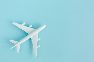 Naklejka na ściany i meble White model plane, airplane on blue background. Top view, flat lay. Travel, vacation concept.
