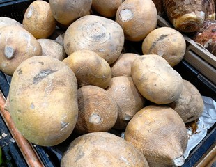 Piles of rootcrops displayed in the fresh produce section of a grocery.