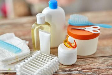 bath time and care products concept - baby accessories for bathing on wooden table at home